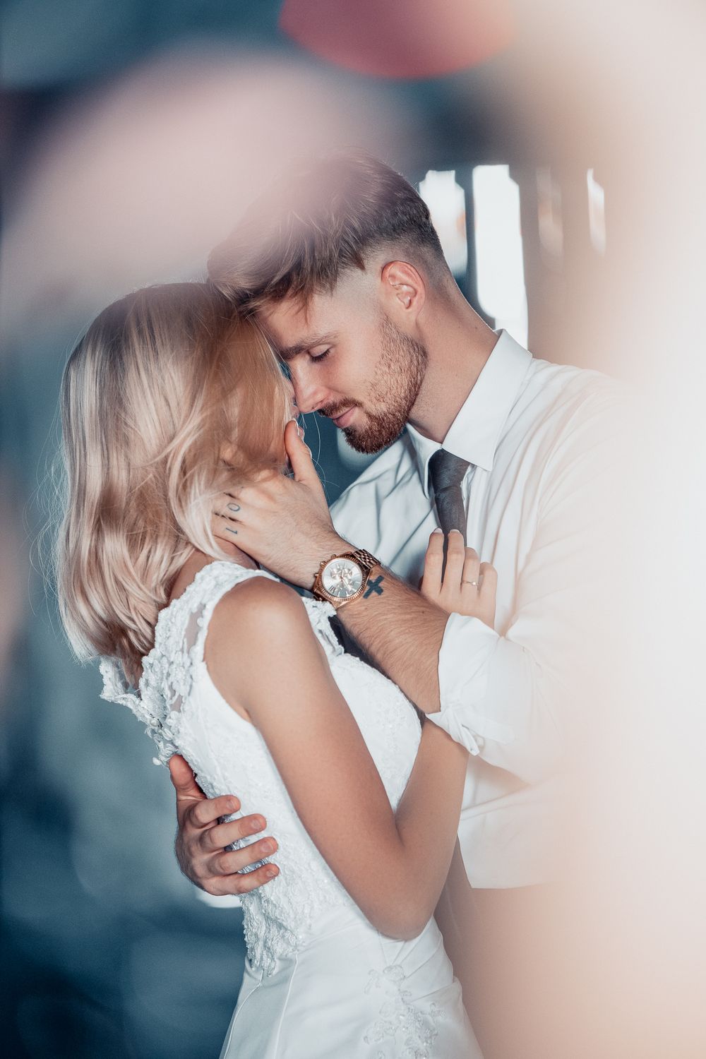 A romantic moment captured between newlyweds in an intimate indoor setting.