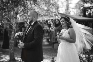 Black and white photo of a bride and groom during their outdoor wedding ceremony.