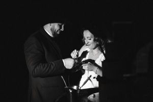 Black and white candid moment at an indoor wedding celebration.