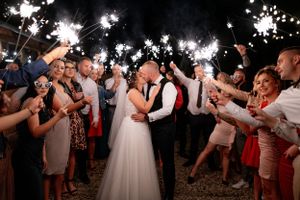 Wedding sparkler exit with couple surrounded by celebrating guests.