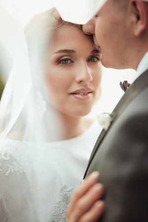 An intimate wedding portrait showing a tender moment between newlyweds.