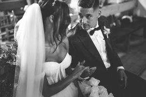 Black and white candid moment of newlyweds during their wedding reception.
