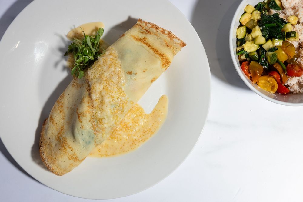 A fresh omelet filled with vegetables and served on a white plate.