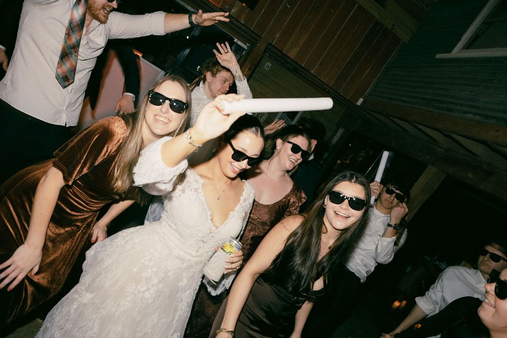 A group of people dancing and celebrating at a dimly lit nightclub party.