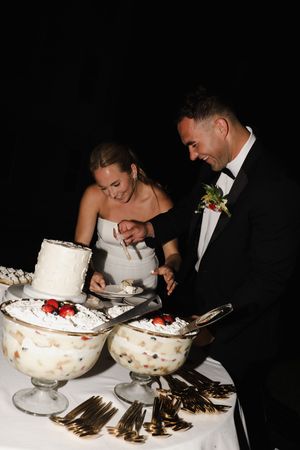 Bride and groom sharing dessert from elegant glass bowls at their wedding reception.