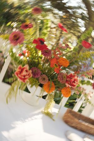 Colorful floral arrangement with red and orange blooms captured in artistic motion blur.