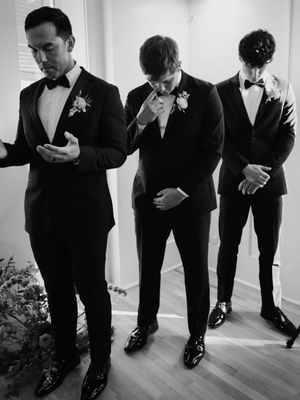 Black and white photo series of groomsmen checking their formal attire.