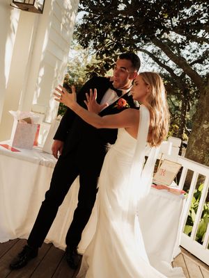 A couple shares an intimate dance moment on a white-columned porch.