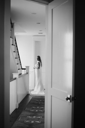 A long white hallway with black and white carpet and white walls creates a dramatic perspective.