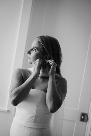 A sequence showing someone in a white dress adjusting their outfit in a hallway.