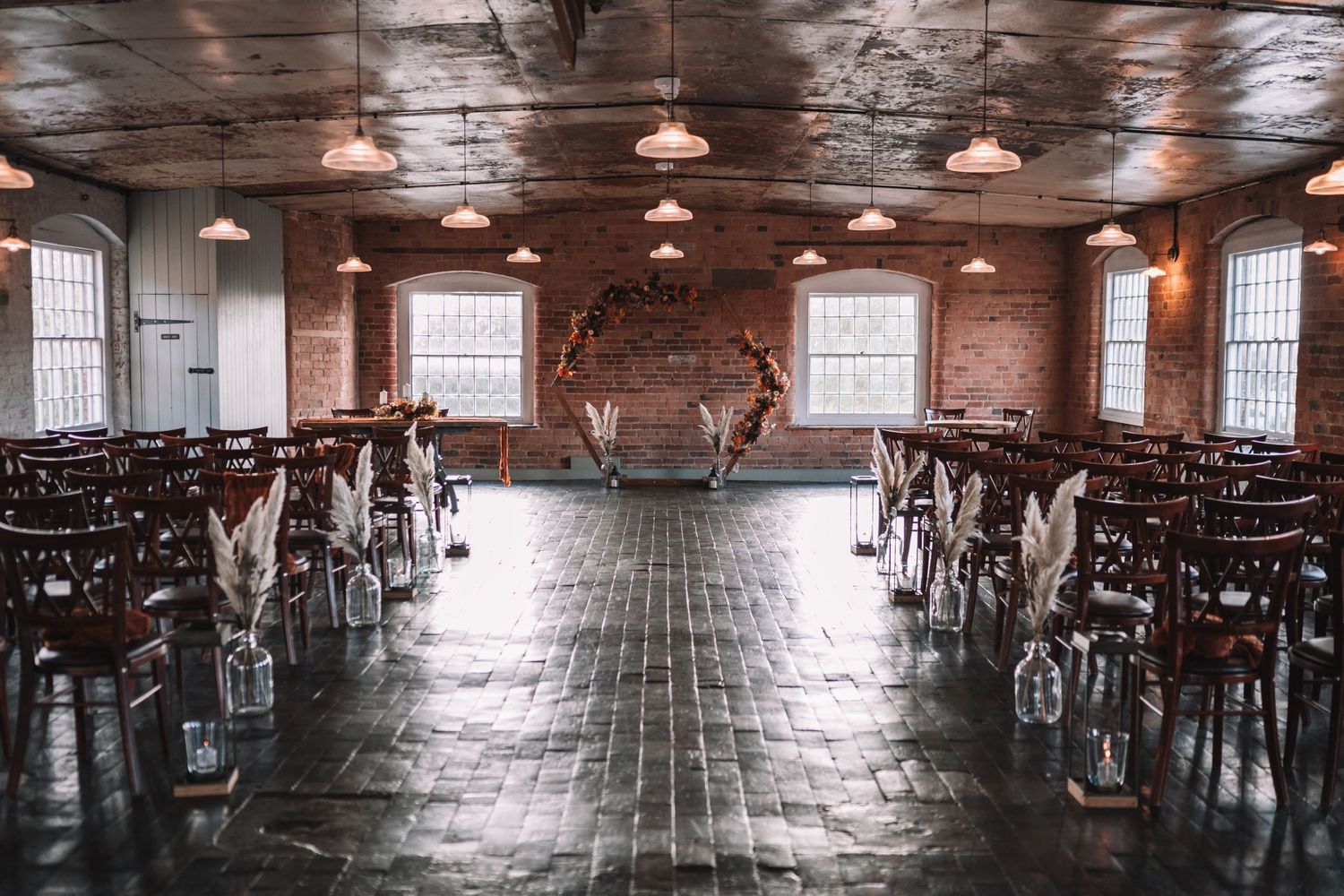 Rustic event venue with exposed brick walls, wooden floors, vintage lighting at the West Mill
