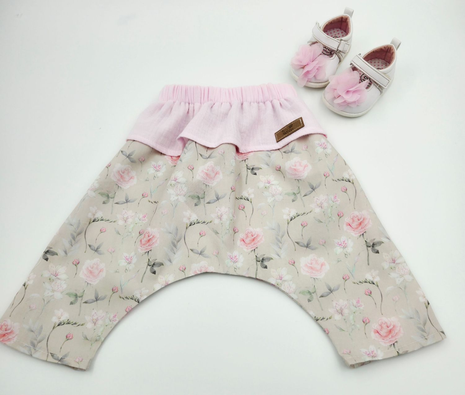 Pink and gray floral baby bloomers with matching shoes displayed on white background.