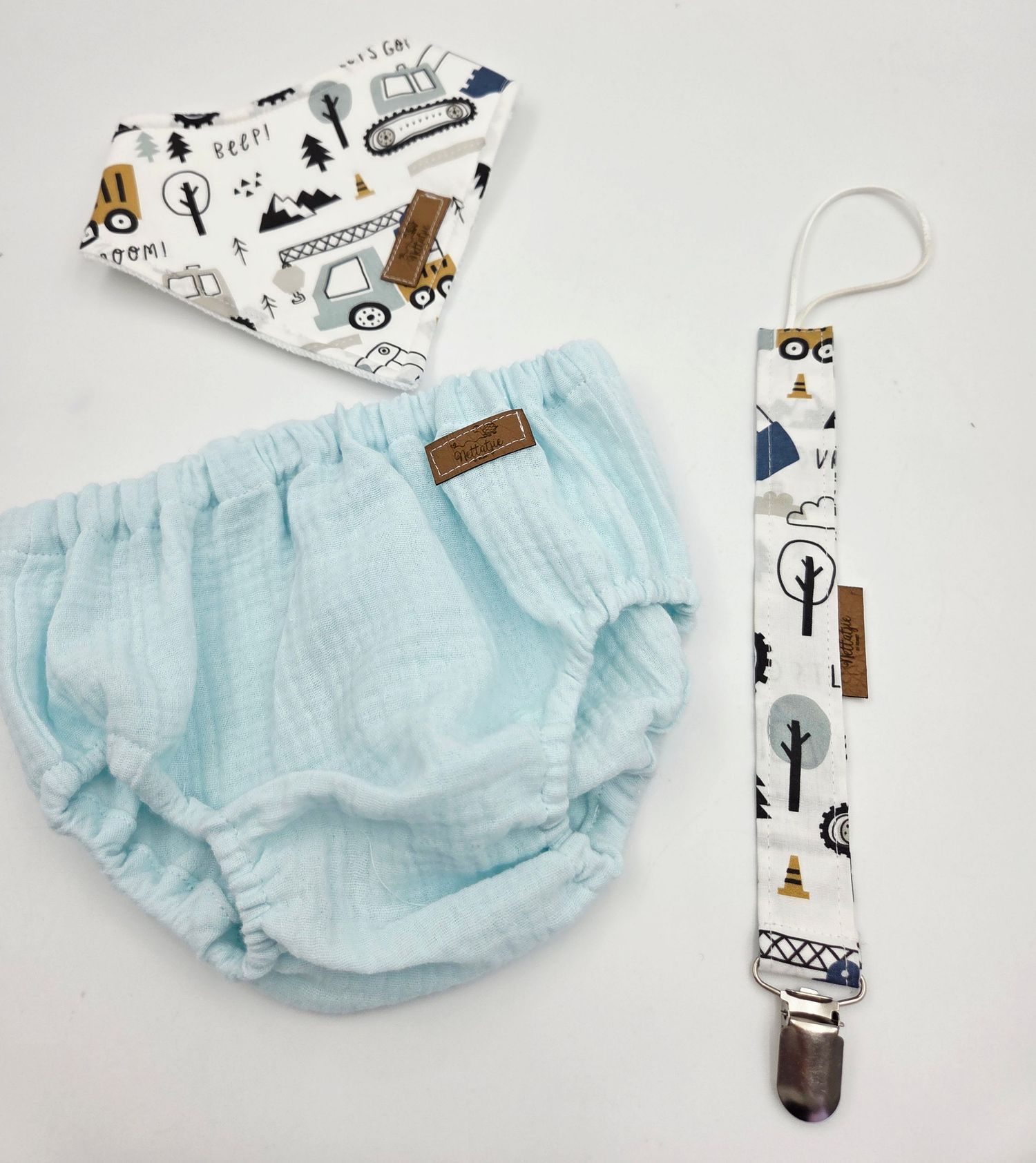 Light blue baby bloomers with woodland print accessories shown on white background.