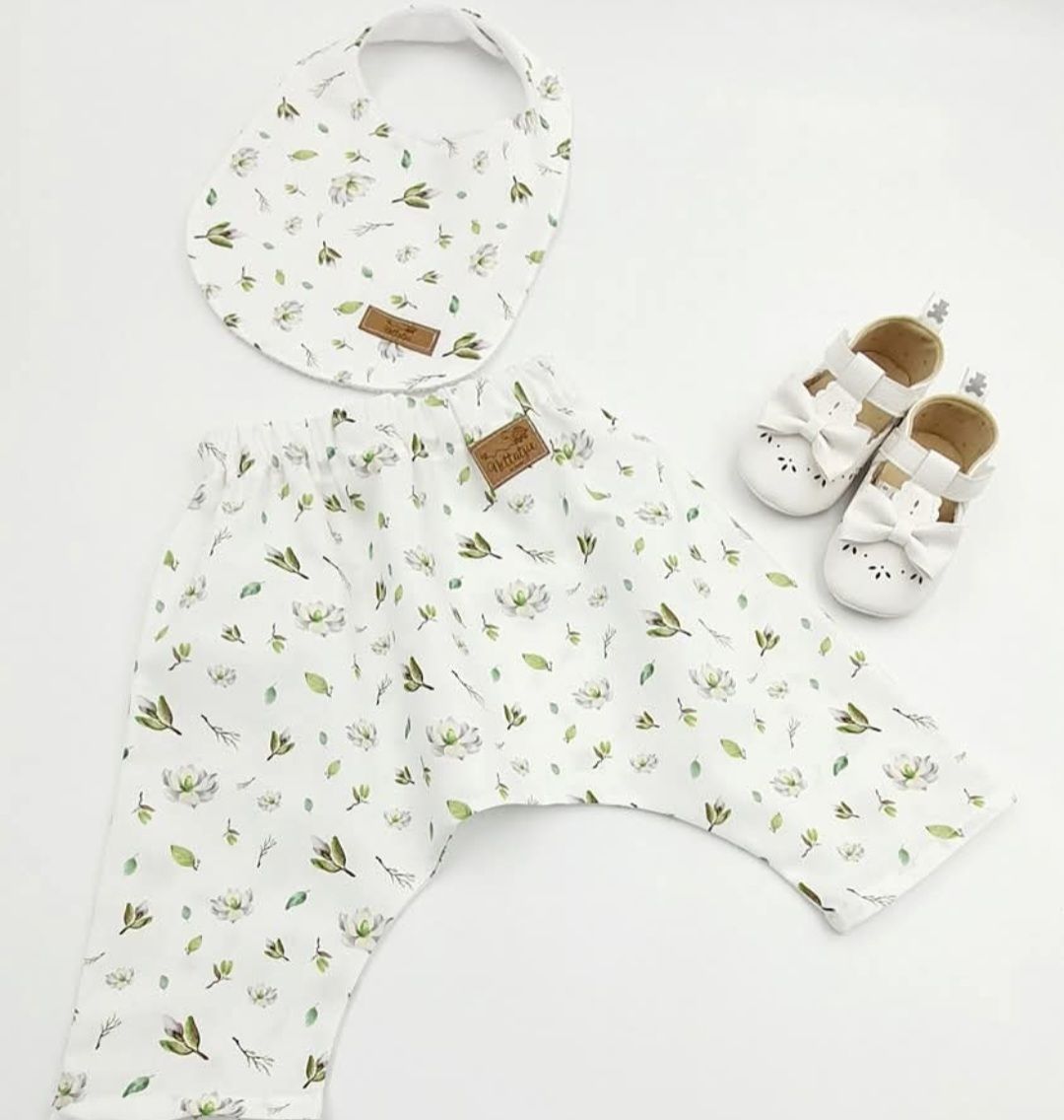 Delicate floral print baby bloomers with matching shoes on white background.