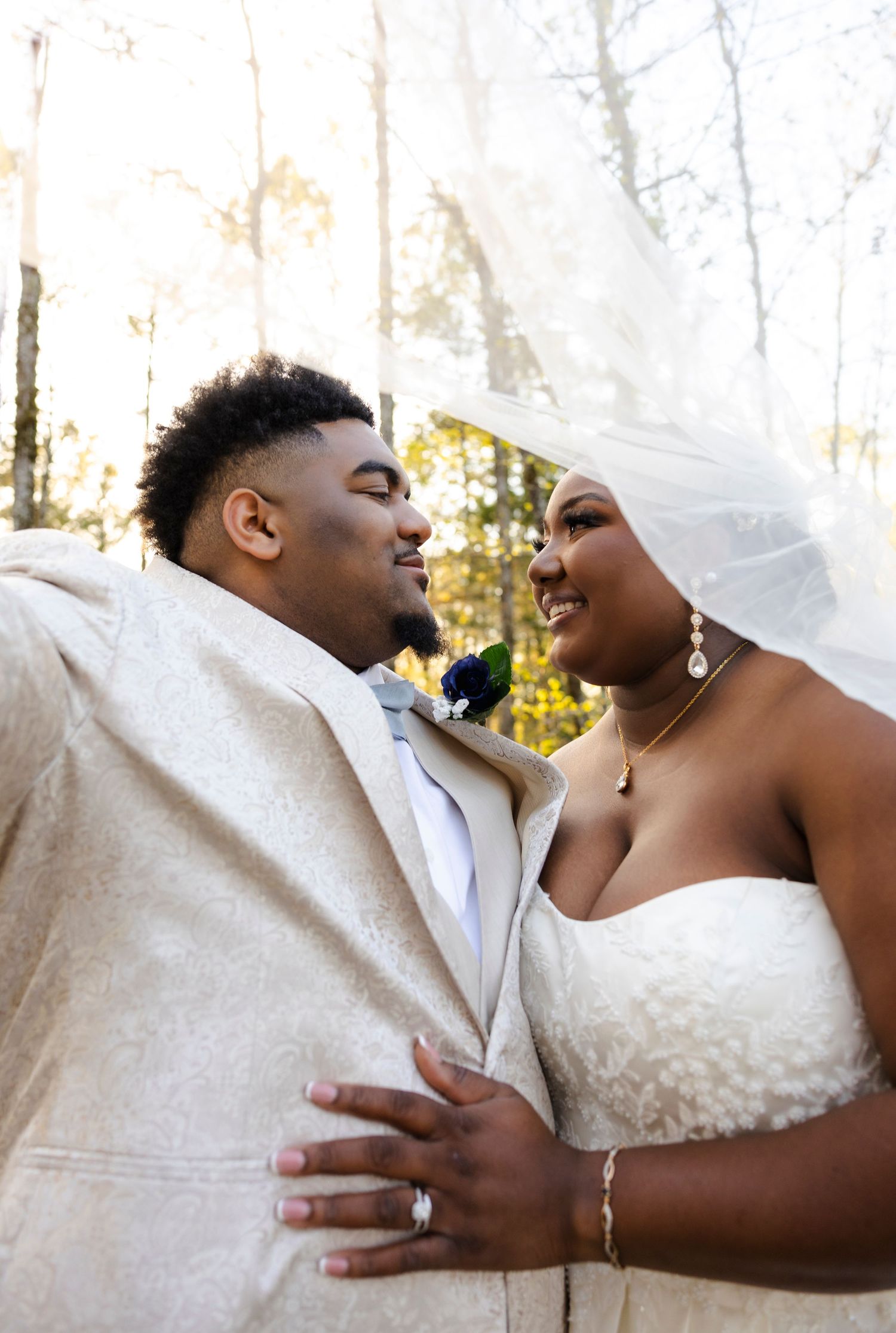 Intimate wedding portrait captured against a soft forest backdrop.