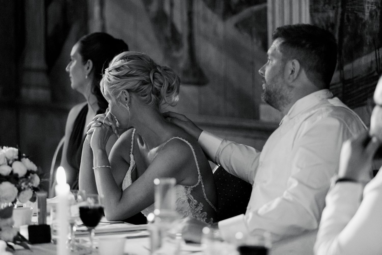 Wedding reception guests seated at an elegant dinner table in black and white.