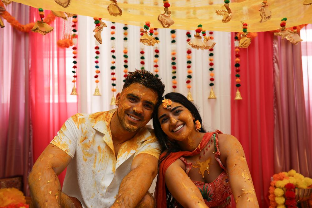 Couple celebrating at a colorful Indian wedding ceremony with festive decorations.
