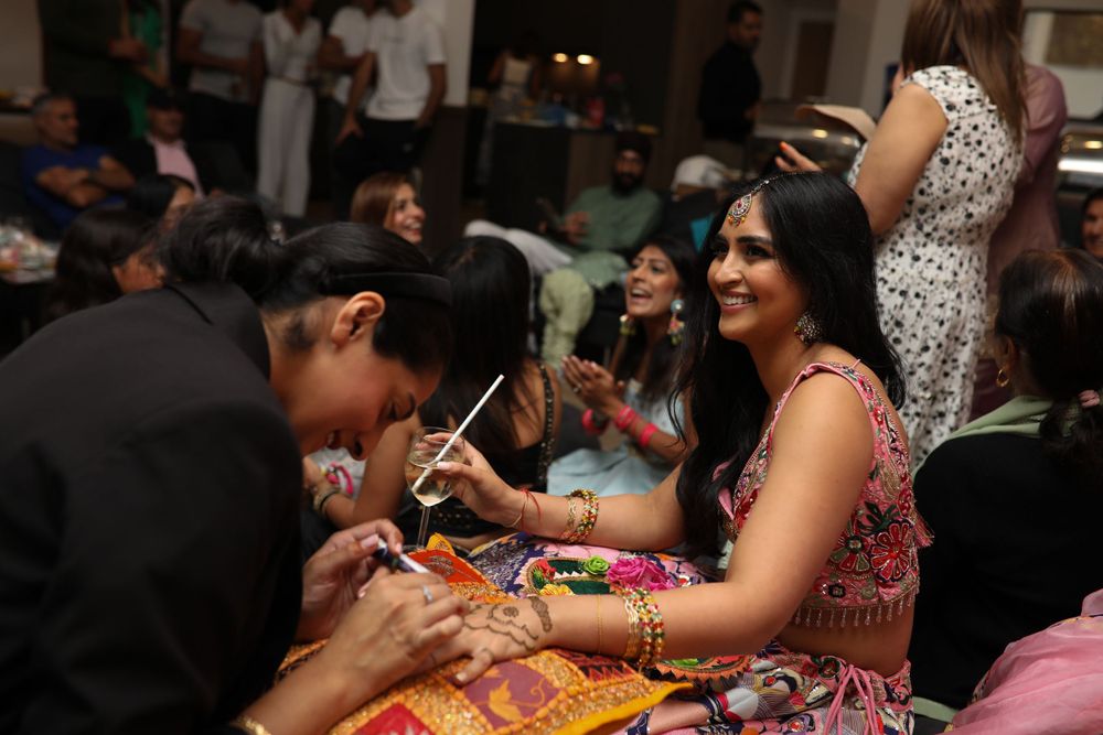 Traditional Indian wedding ceremony with guests celebrating in a decorated room.