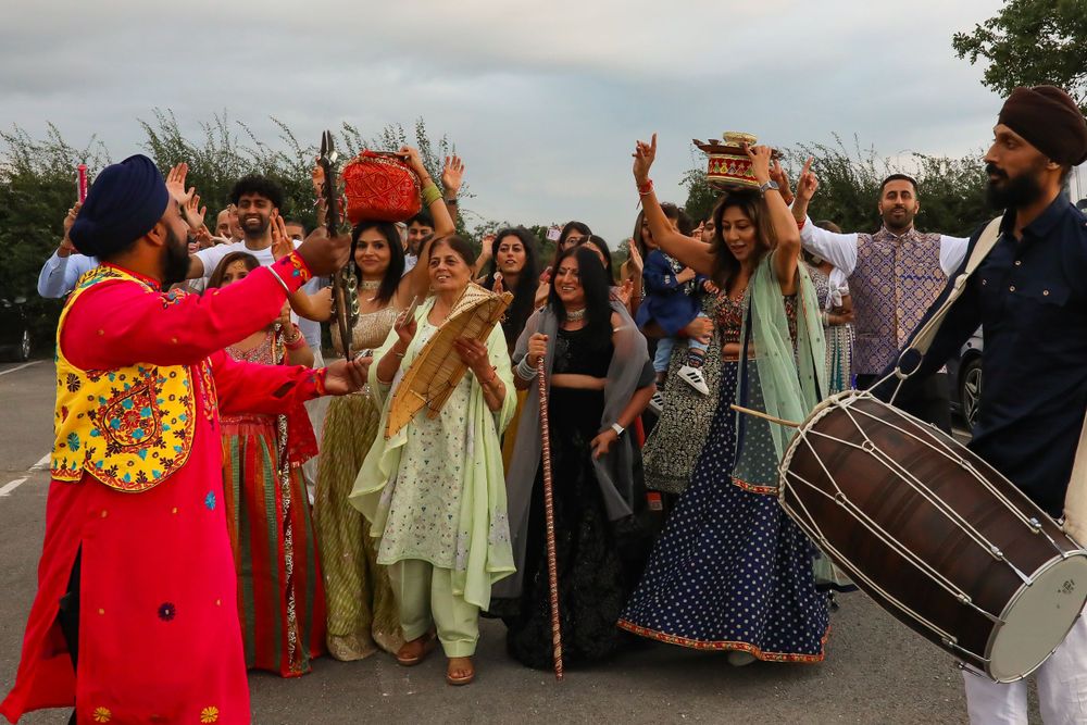 Festive dancers and musicians celebrate at an Indian wedding with traditional instruments and colorful outfits.