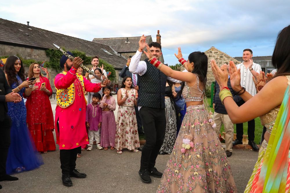Wedding guests dance and celebrate during a lively outdoor reception party.