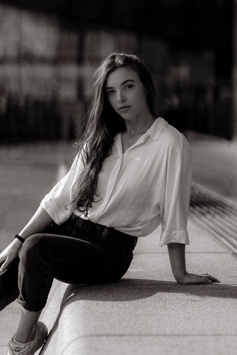 Black and white artistic photo series showing a person in a white shirt and dark pants reclining on the ground.