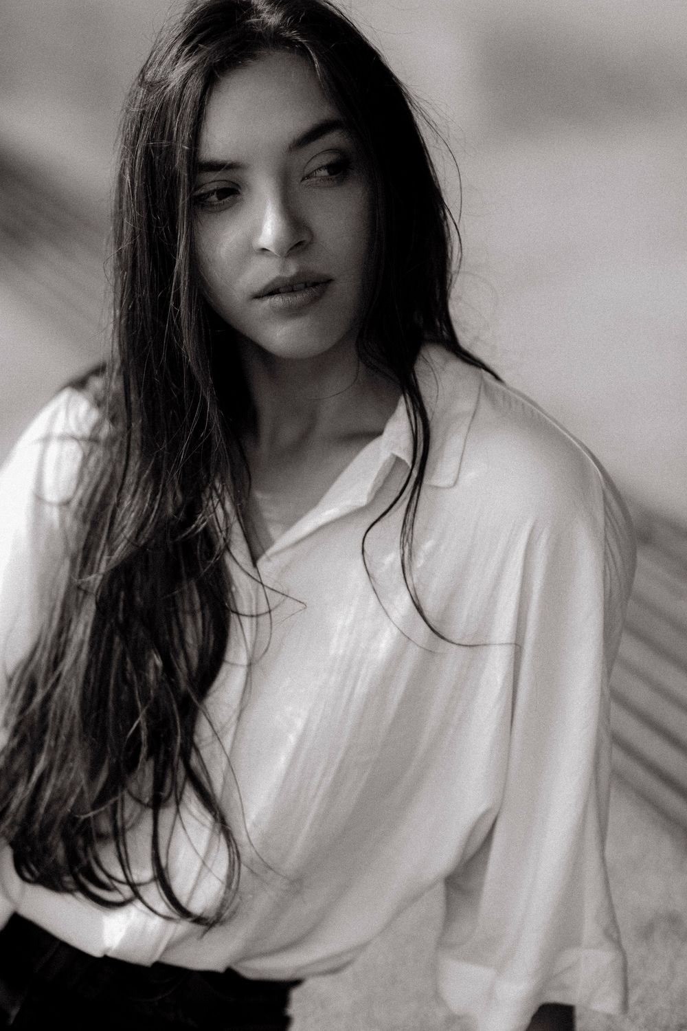 A series of black and white artistic self portraits showing someone in a white shirt with dark hair against a light background.