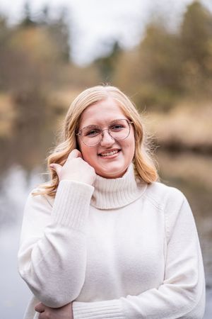 A person in a white turtleneck sweater poses outdoors in a series of casual portraits.