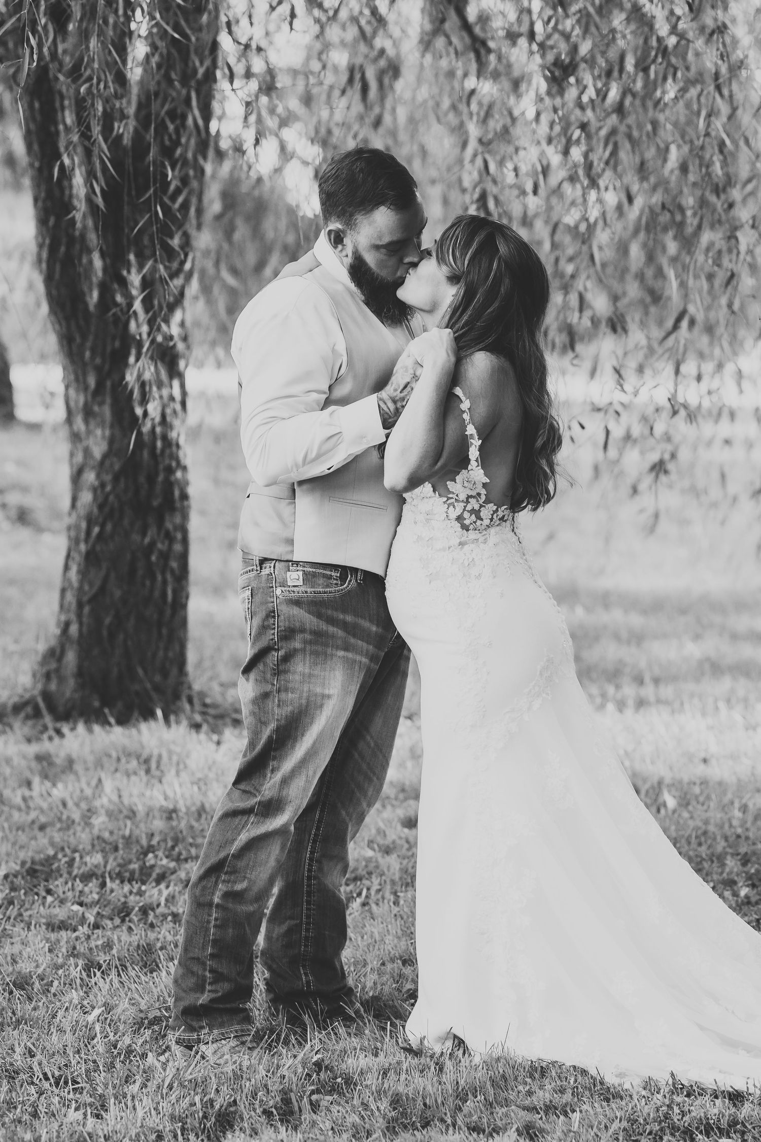 Black and white wedding portraits under weeping willow trees in dreamy outdoor setting in West Virginia.