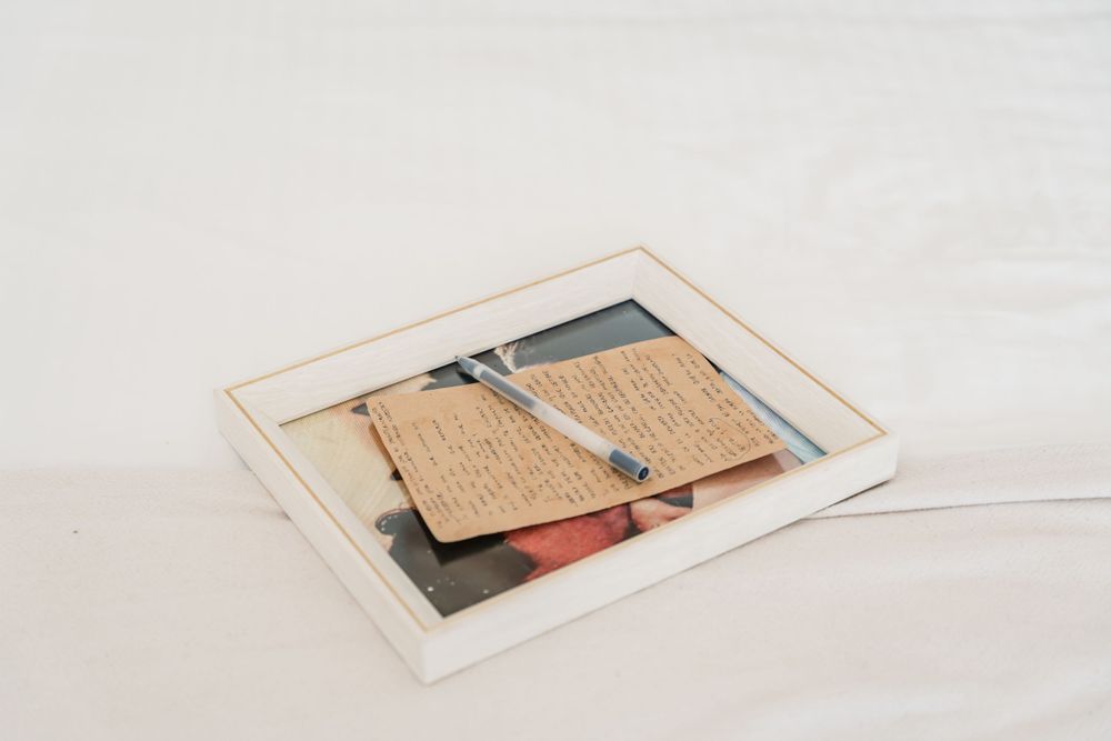 Wedding invitation and cards displayed in minimal white box frame.