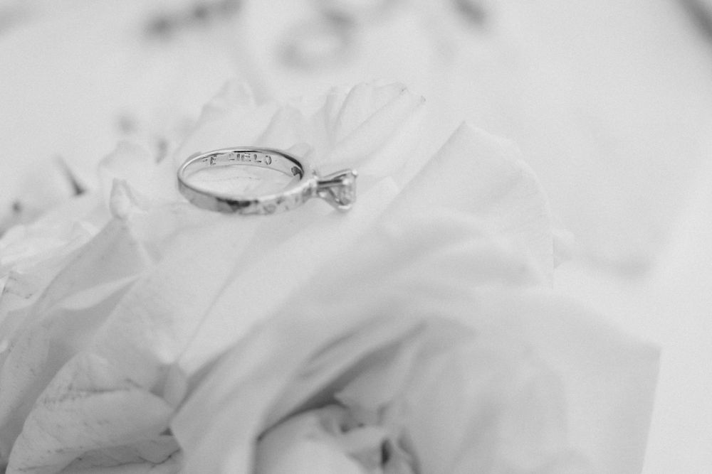 Wedding ring with diamond macro shot on white flower petals.