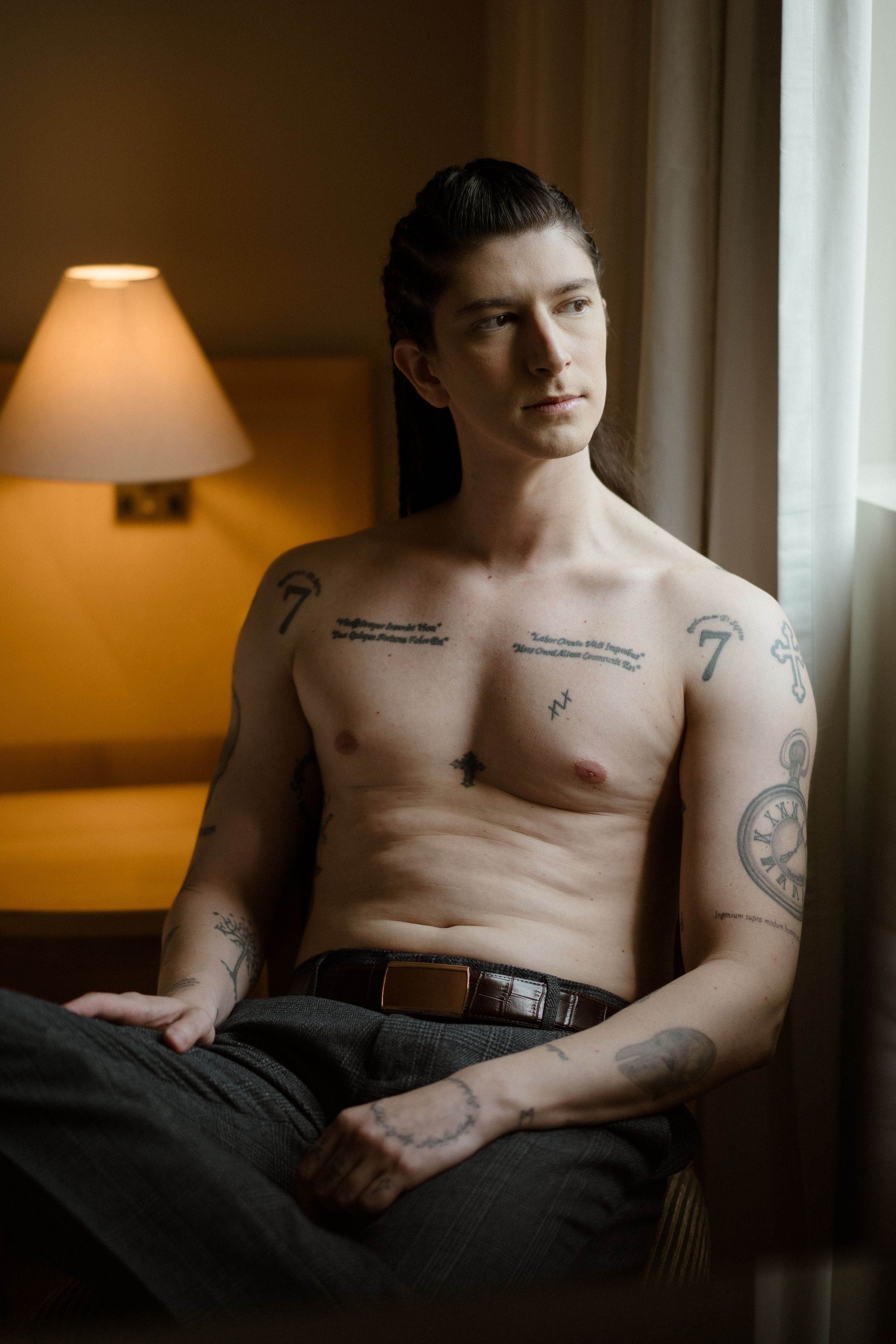 Intimate boudoir photograph showing tattoos in natural window lighting.