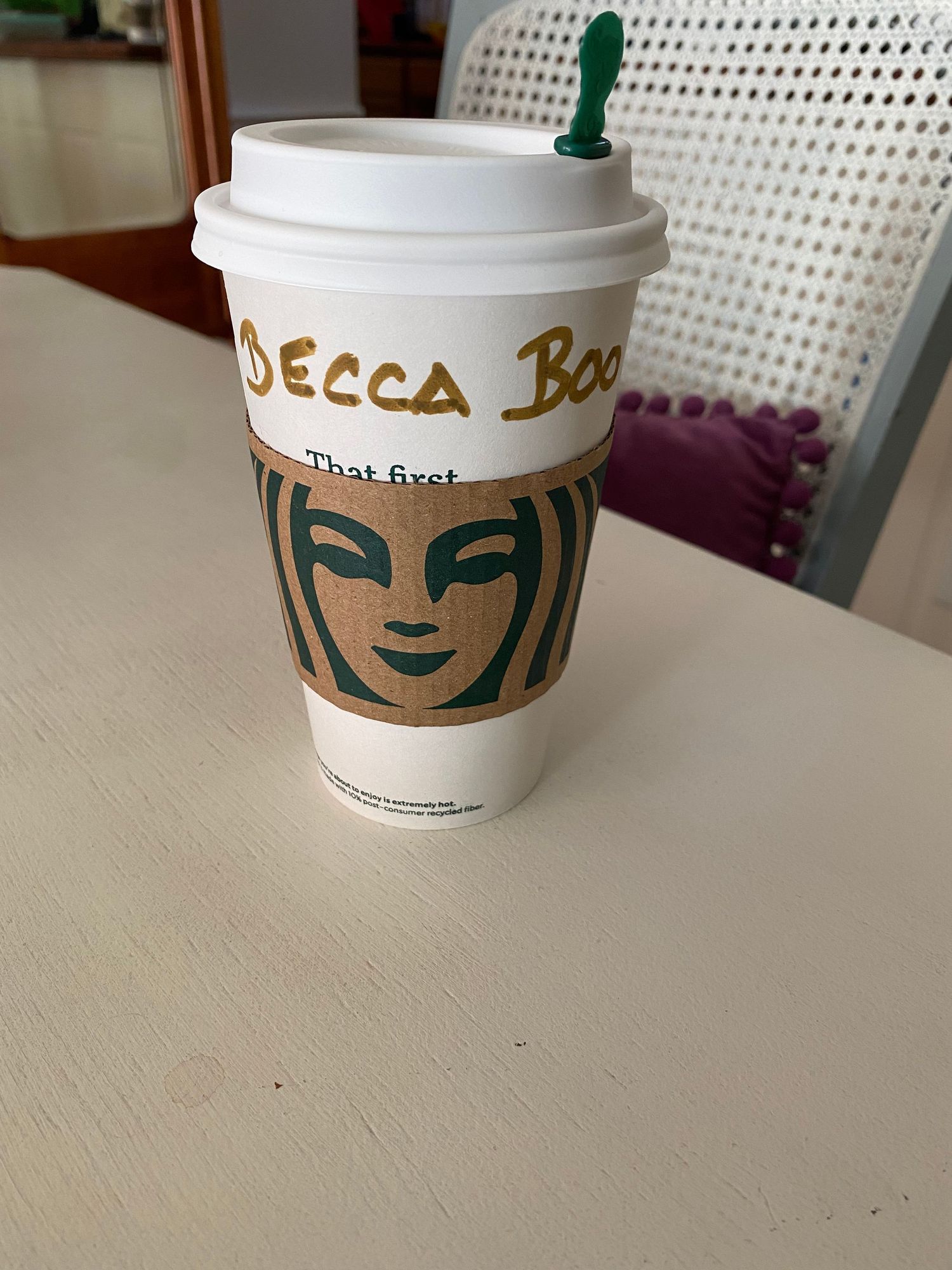 Starbucks coffee cup with name written on white paper cup.