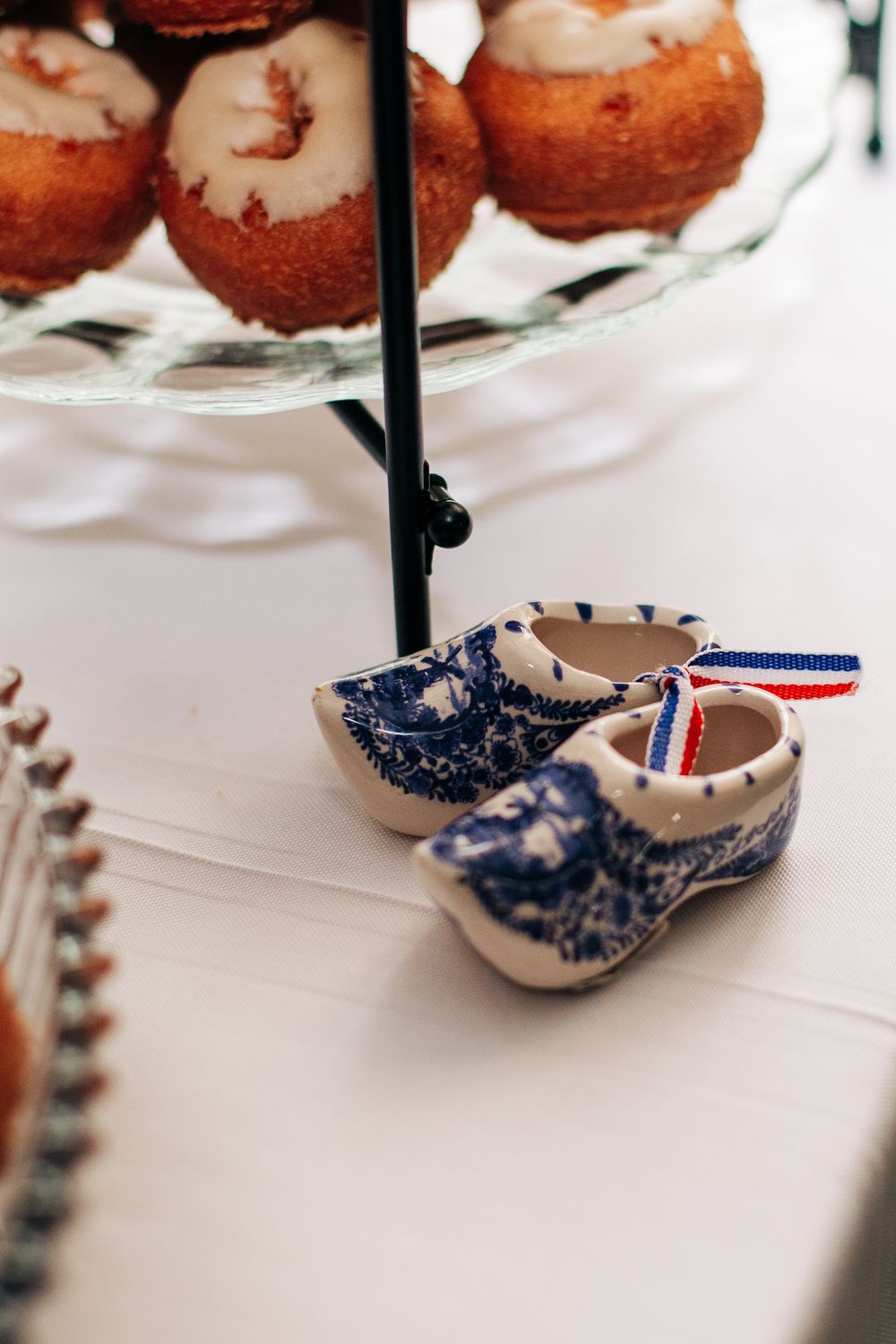 Decorative blue and white Dutch ceramic clogs displayed beneath desserts at wedding reception.
