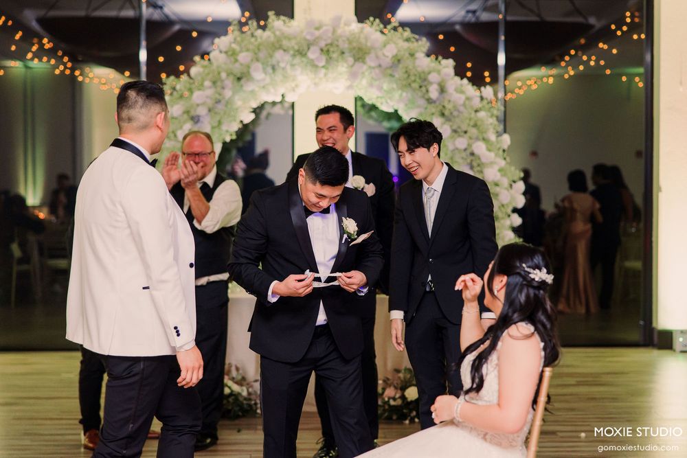 Elegant wedding ceremony space with white floral arch and romantic lighting.