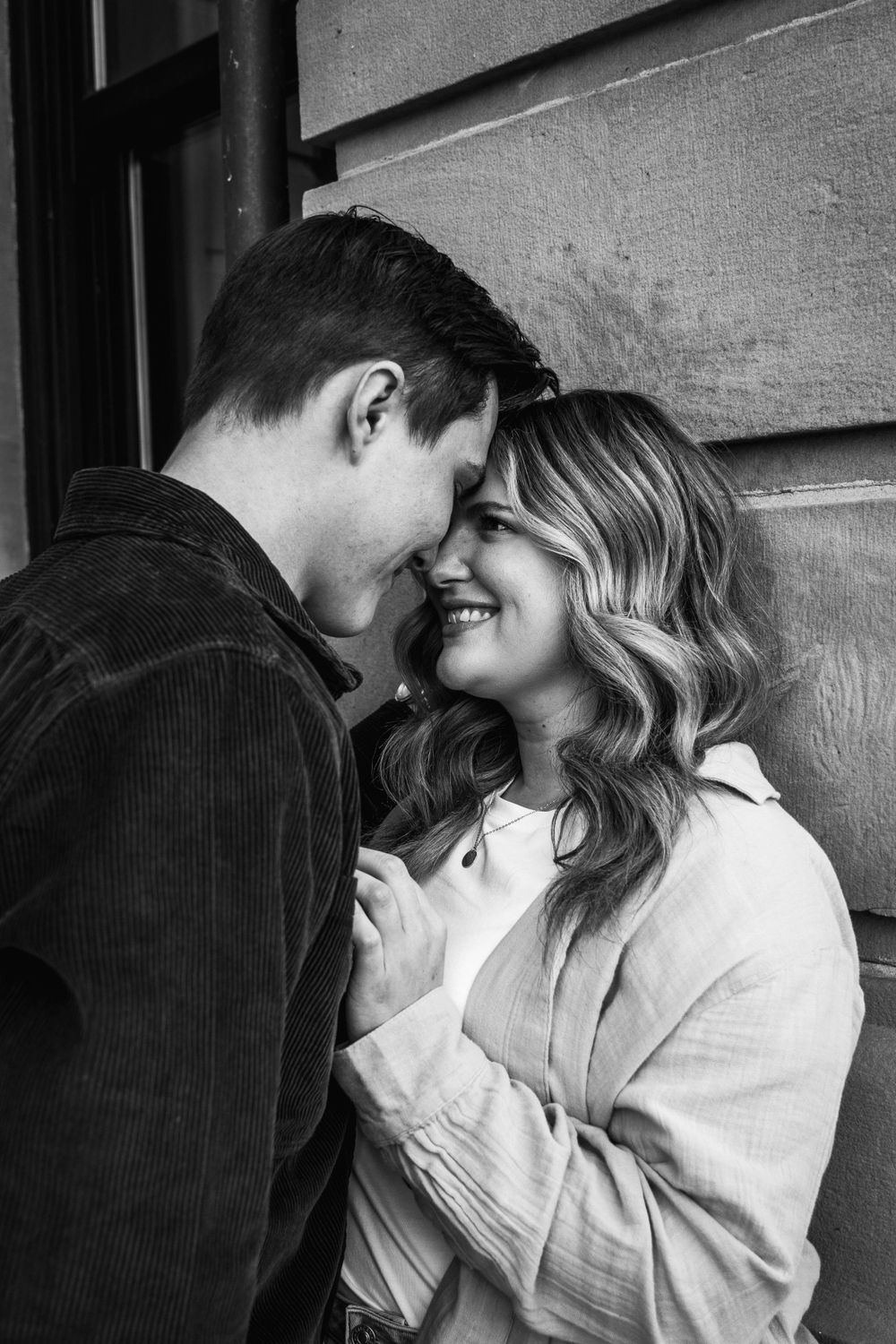 A black and white intimate portrait of a couple sharing a close moment.