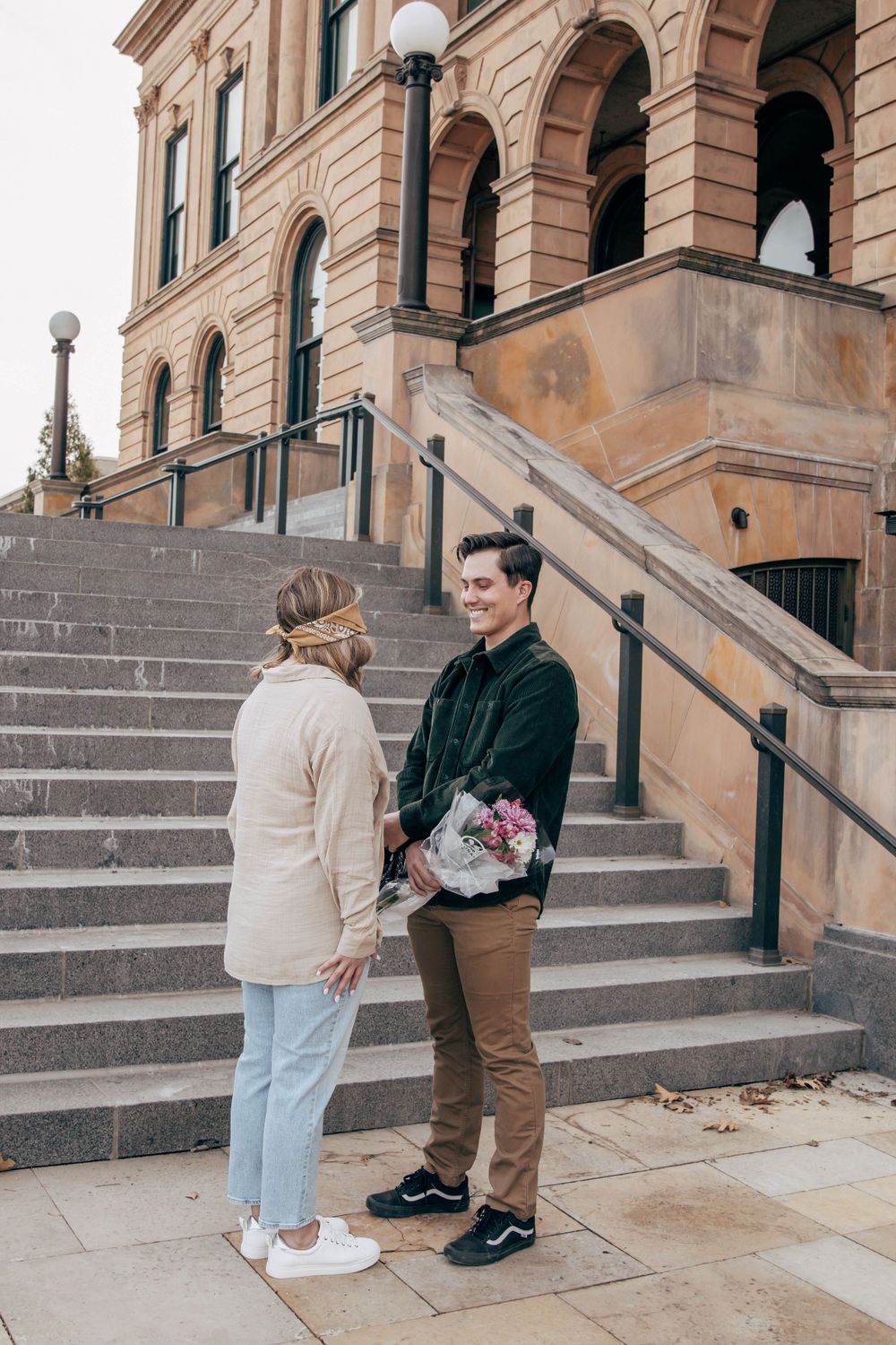 Two people talking on steps of classical architecture building.