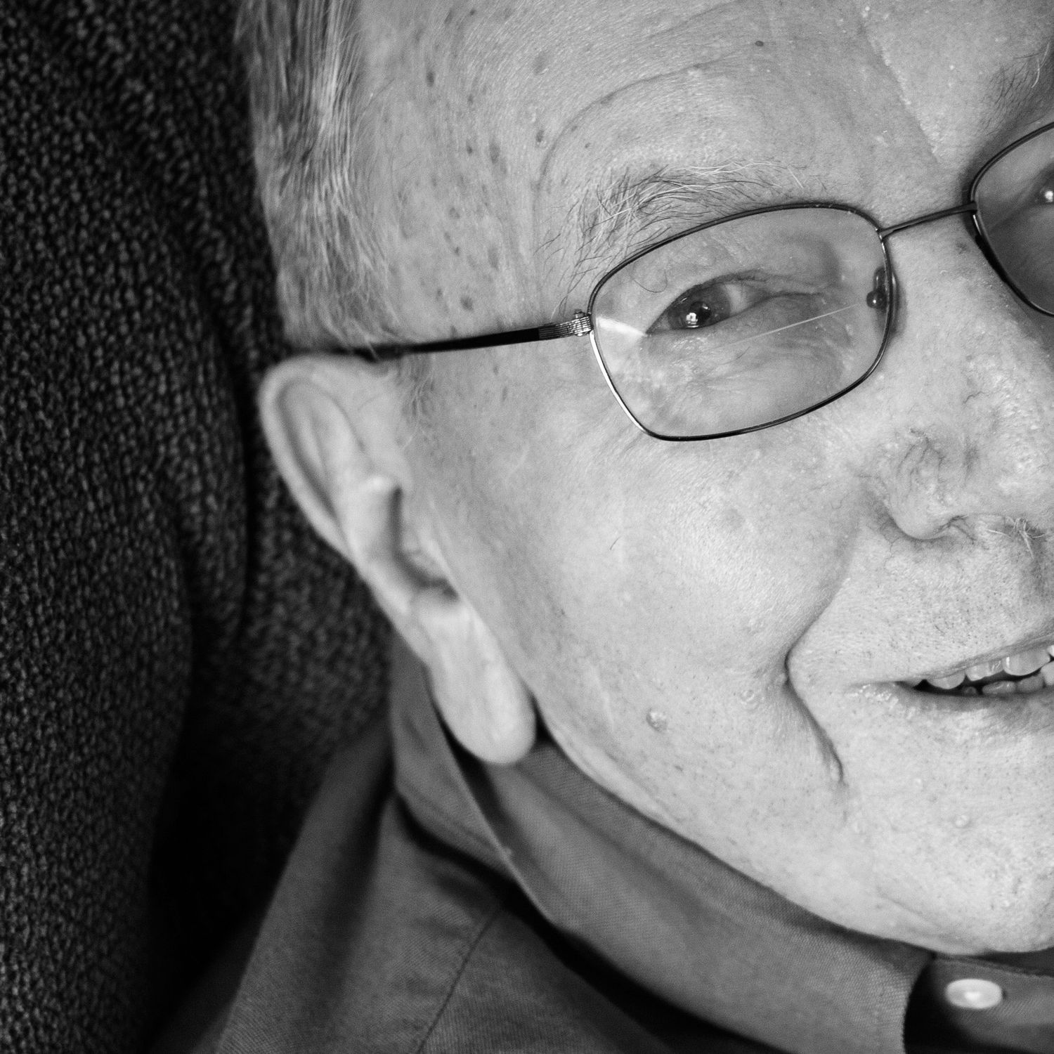 elderly man smiles at camera, face cropped