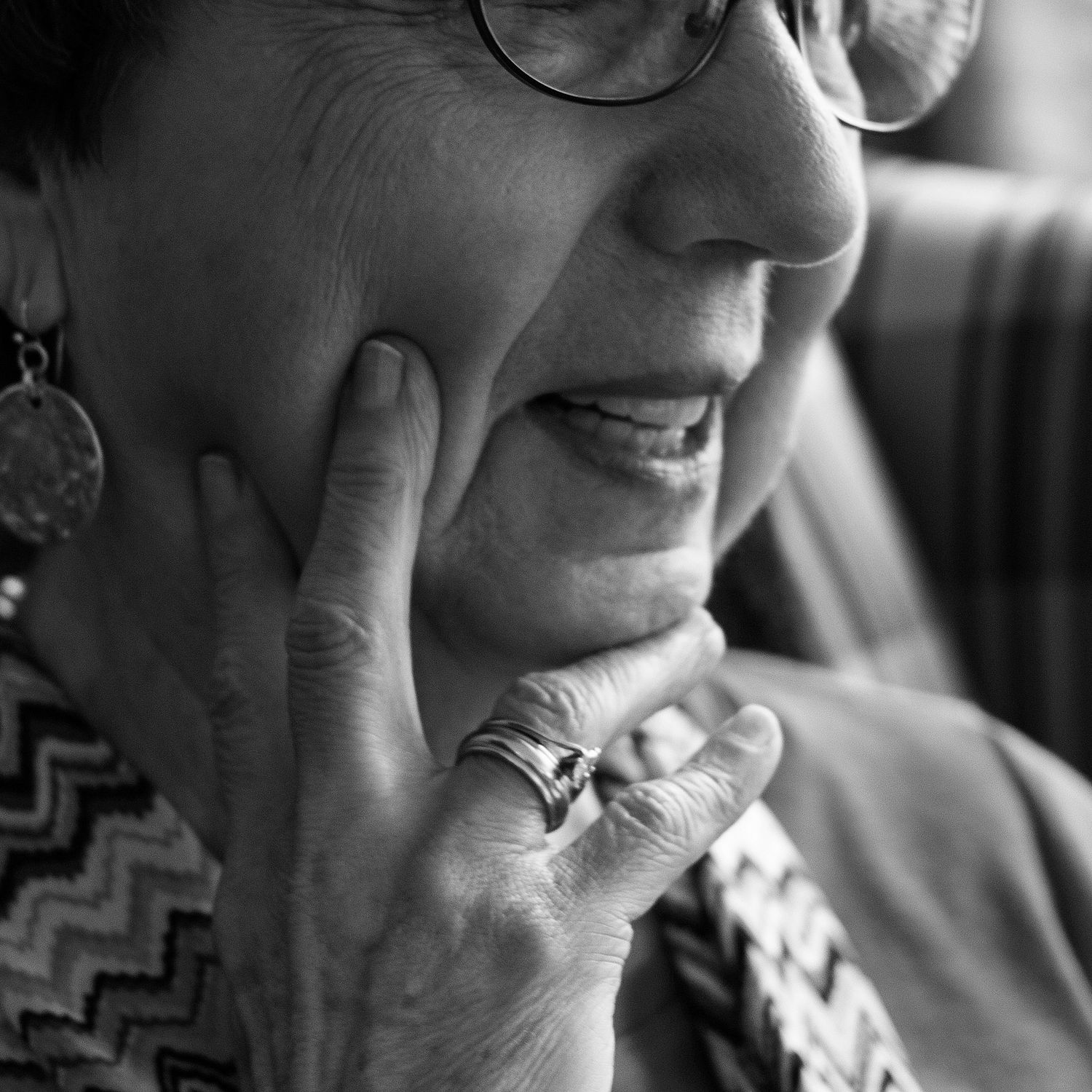 hand pressed to woman's face as if deep in thought, half smiling