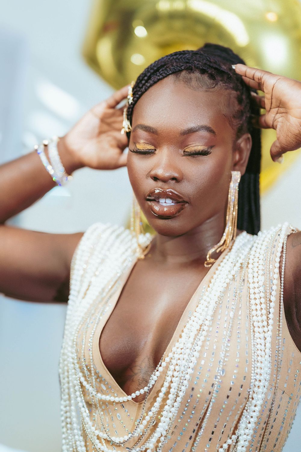 Glamour portrait showing detailed pearl embellishments on cream-colored dress.