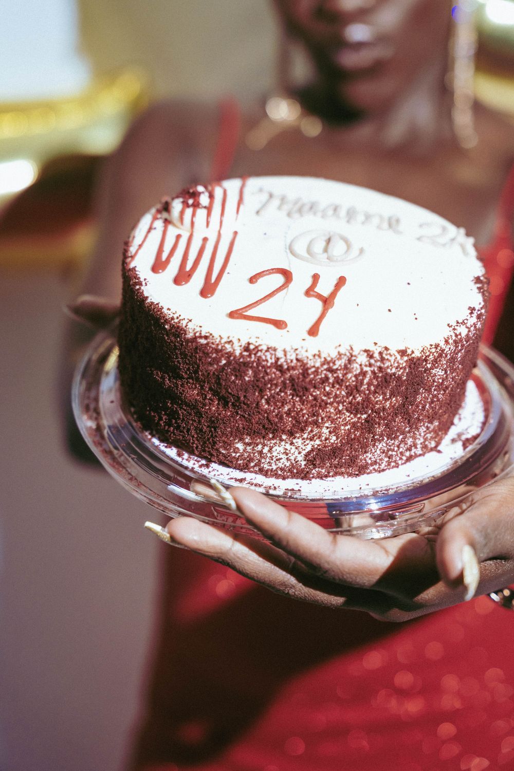 Close up of red velvet birthday cake with white frosting showing number 24.