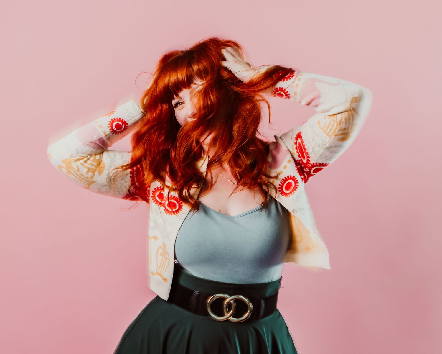 Redhead woman shaking head with pink backdrop