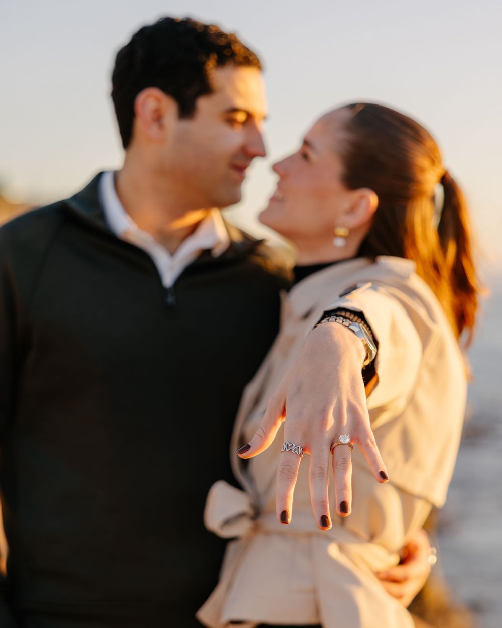 A tender moment captured between a couple during golden hour at the beach.