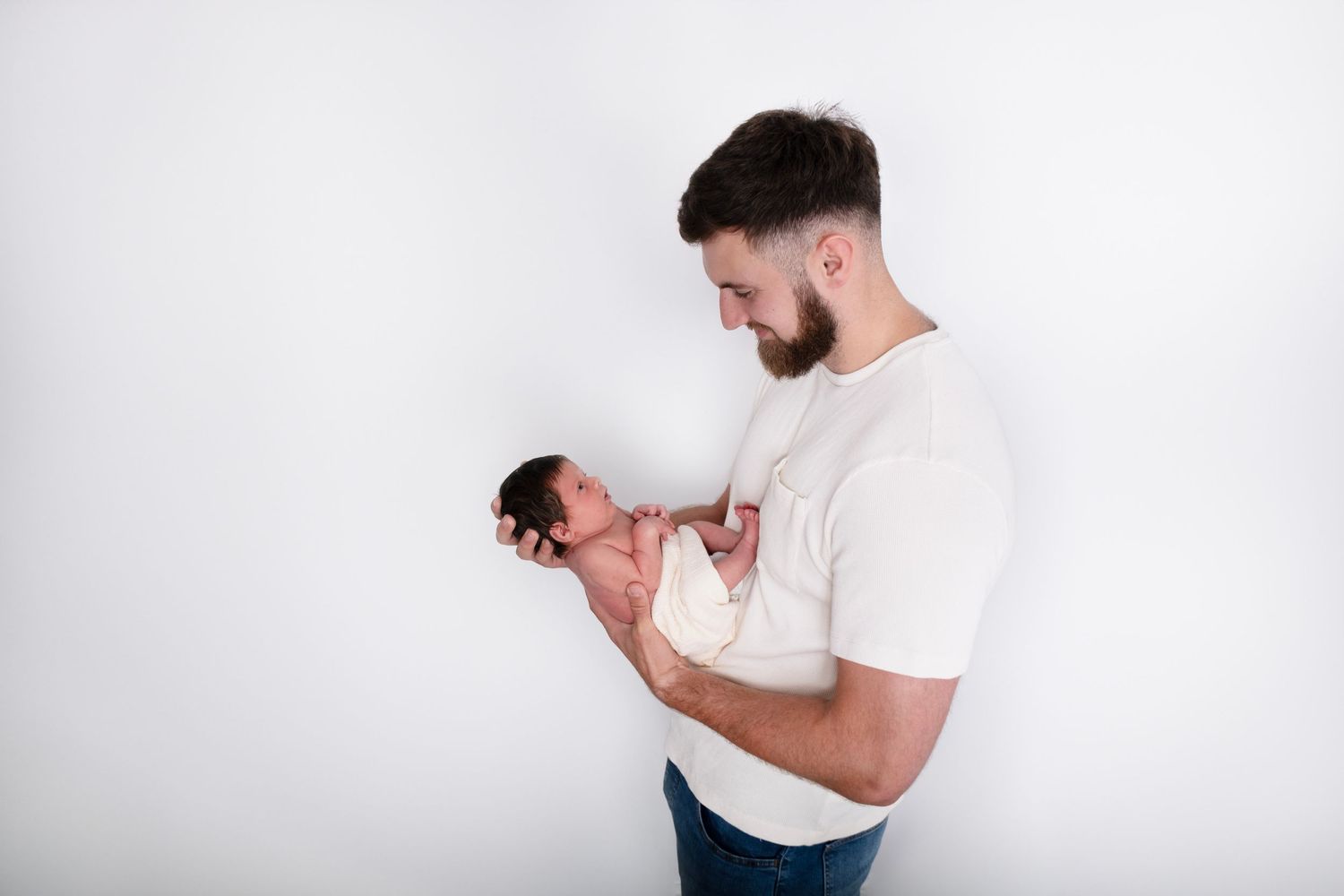 father holding newborn baby girl in arms