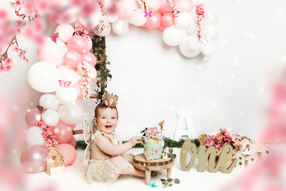 Spring-themed photo setup with cherry blossoms, white balloons, and pink floral accents.