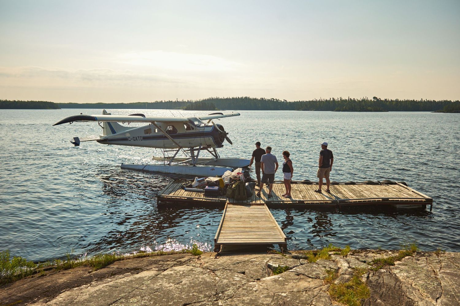 Panoramic view of wooden docks and seaplanes on a serene northern lake.