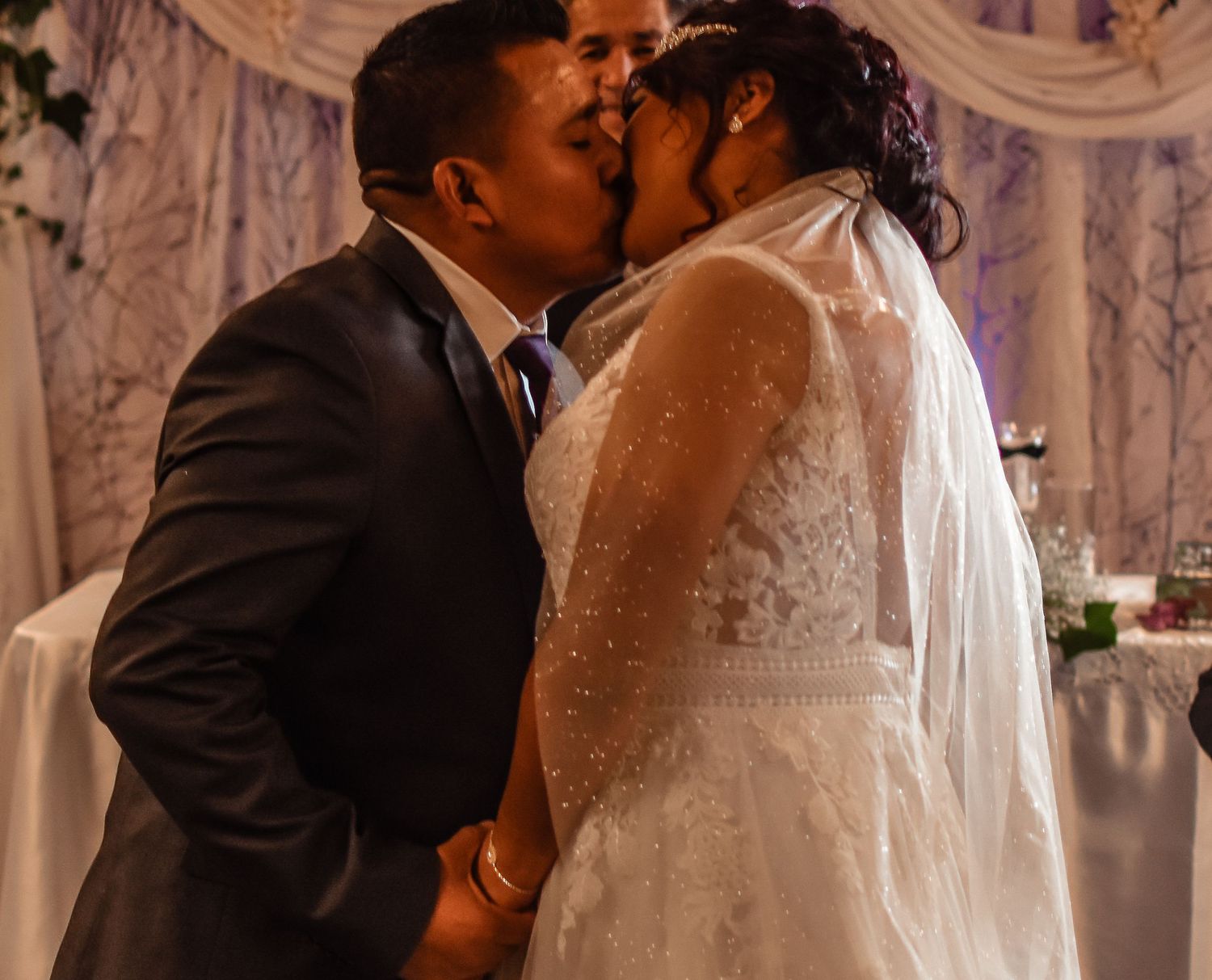 Newlyweds sharing their first kiss during wedding ceremony.