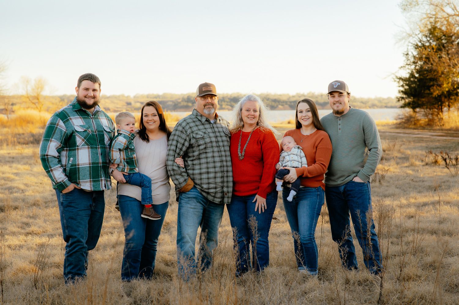 Family of 8 smiling and looking at the camera during their Enid family photoshoot with Taryn Elizabeth, an Enid Family Photographer.