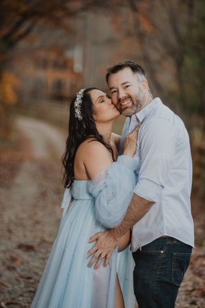 Intimate maternity portraits captured in a natural autumn setting with soft lighting.