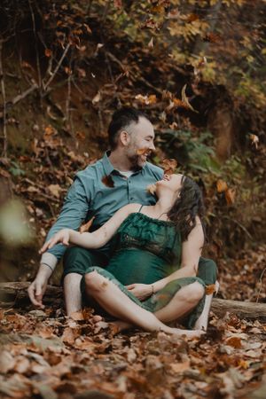 Intimate couples photography session with subjects lying in fallen autumn leaves.