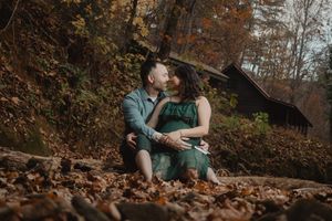 Couple's autumn photoshoot showing intimate moments against fall foliage backdrop.
